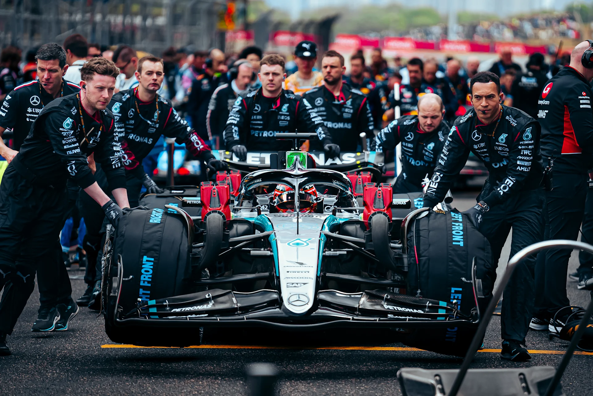 A team pushing the car on the grid
